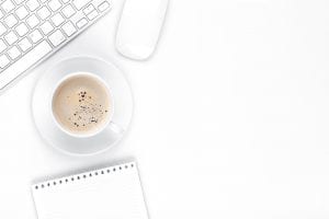 Office desk table with computer, supplies and coffee cup