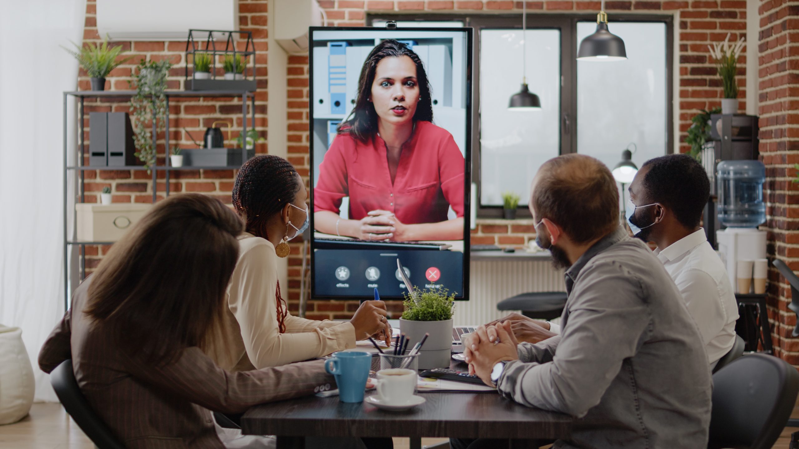Colleagues meeting with woman on video call conference